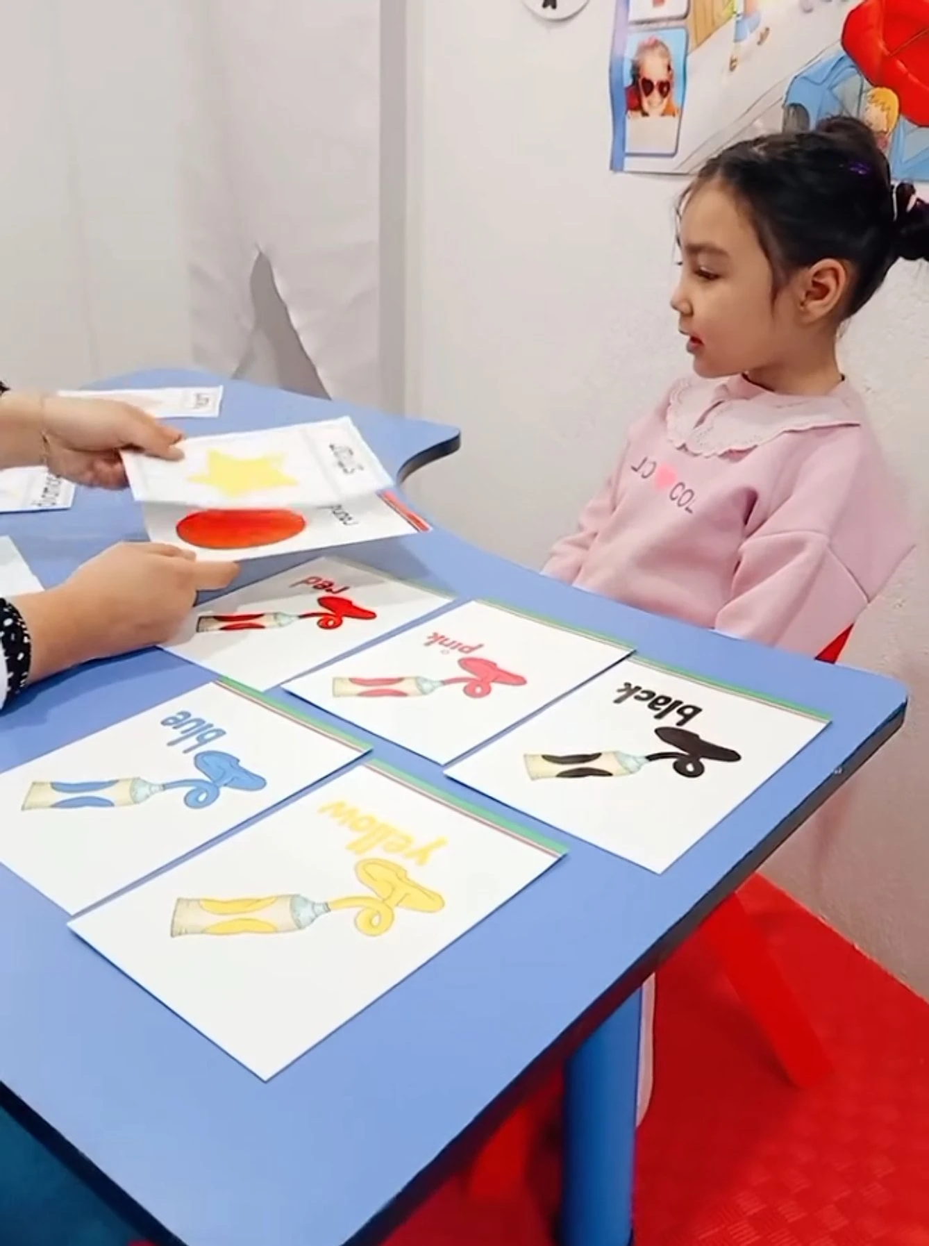 İngilizce dersinde renk kartlarıyla çalışan çocuk ve öğretmen