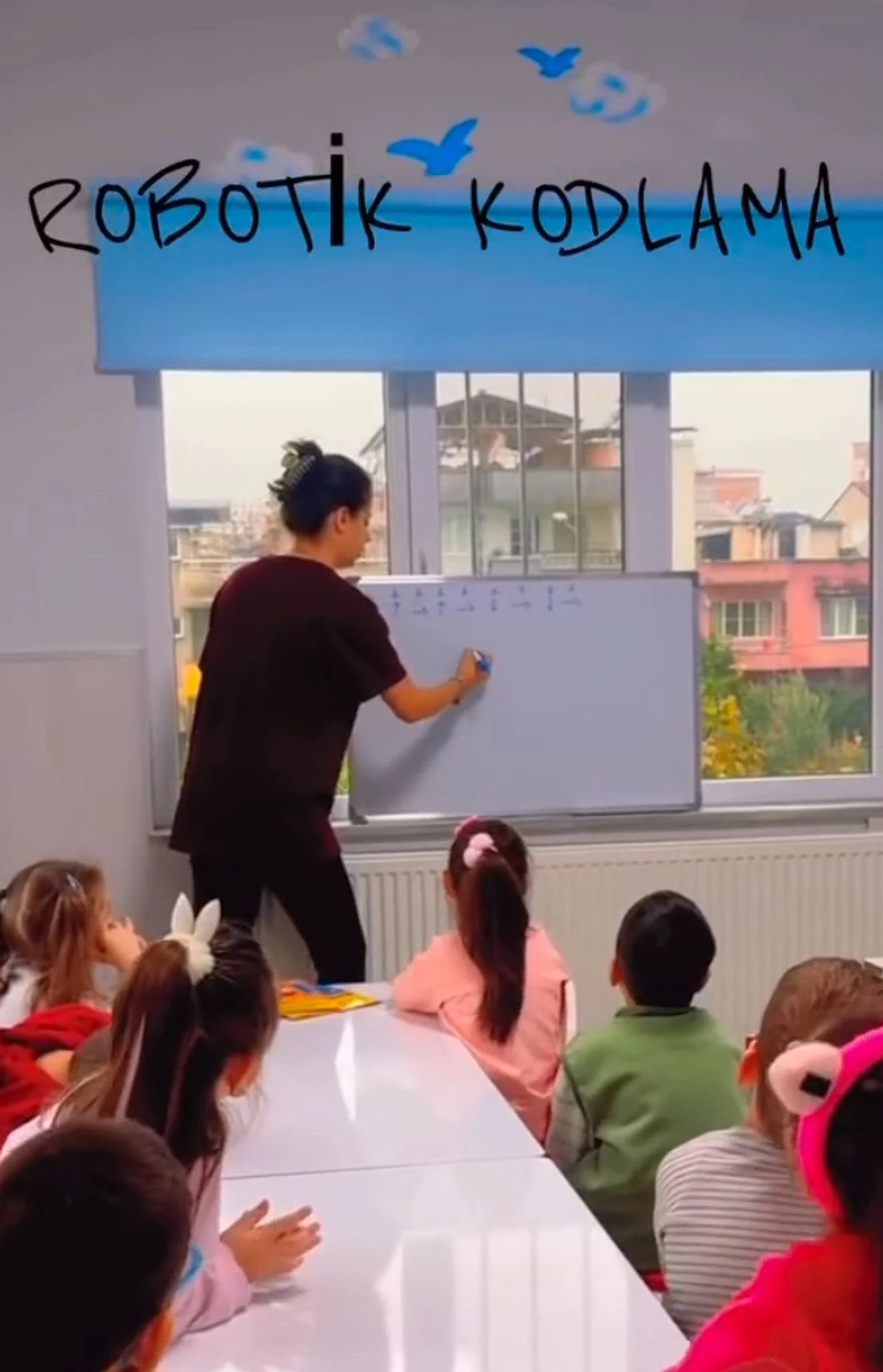 Robotik kodlama dersinde tahtaya komut dizisi yazan öğretmen